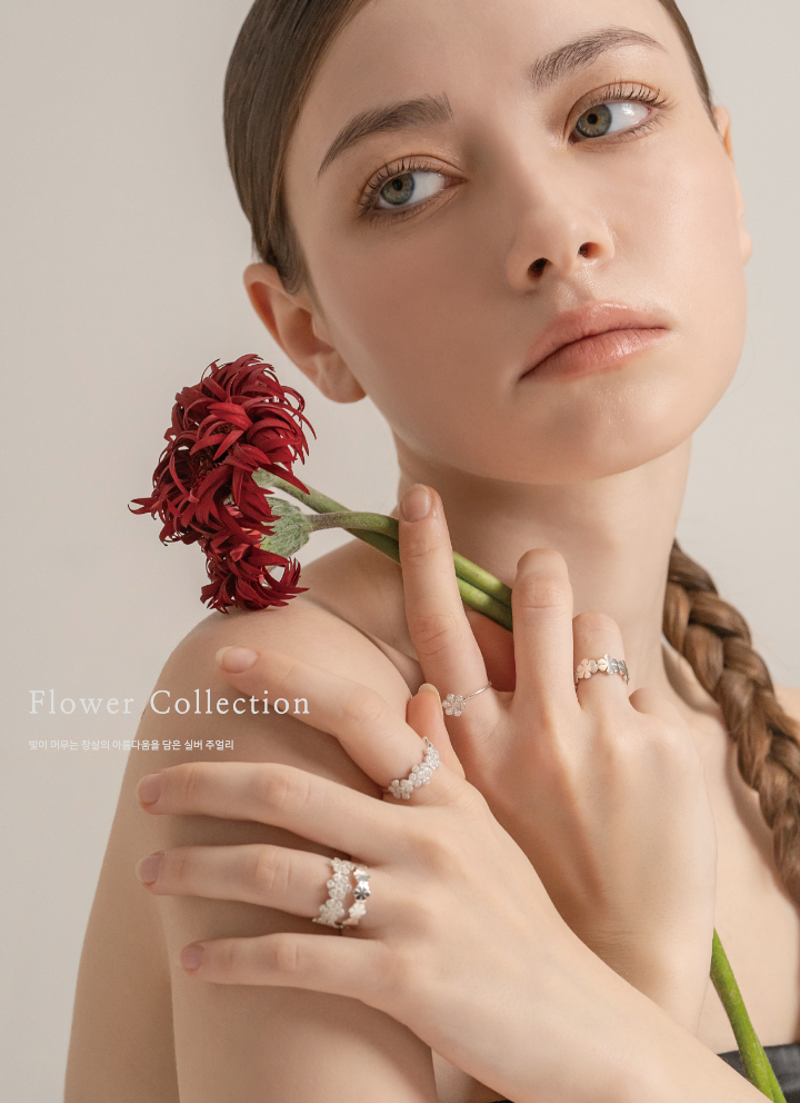 Model wearing Lattice Collection floral rings with a deep red flower